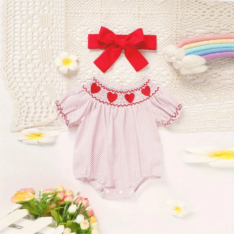 Pink polka dot baby romper with heart embroidery and ruffle detail