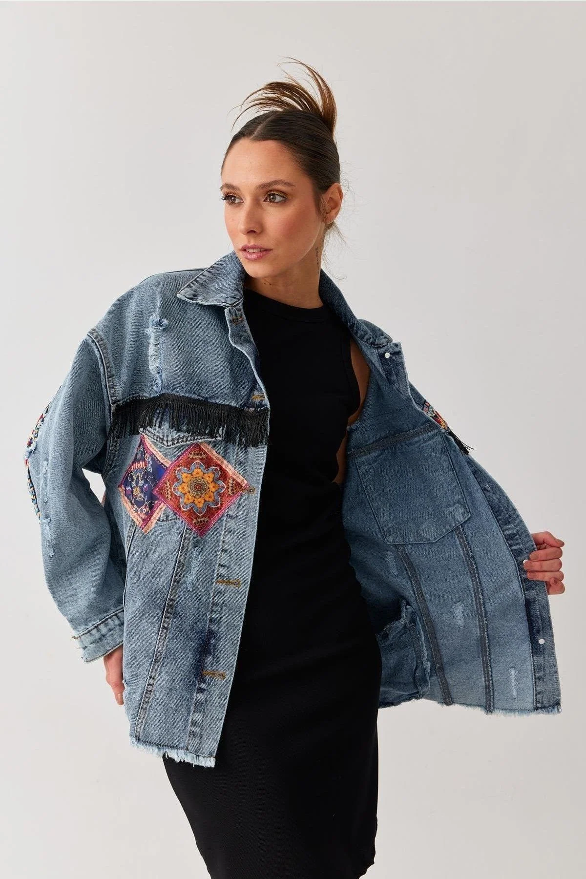 Oversized denim jacket with ethnic patterned pockets and tassels